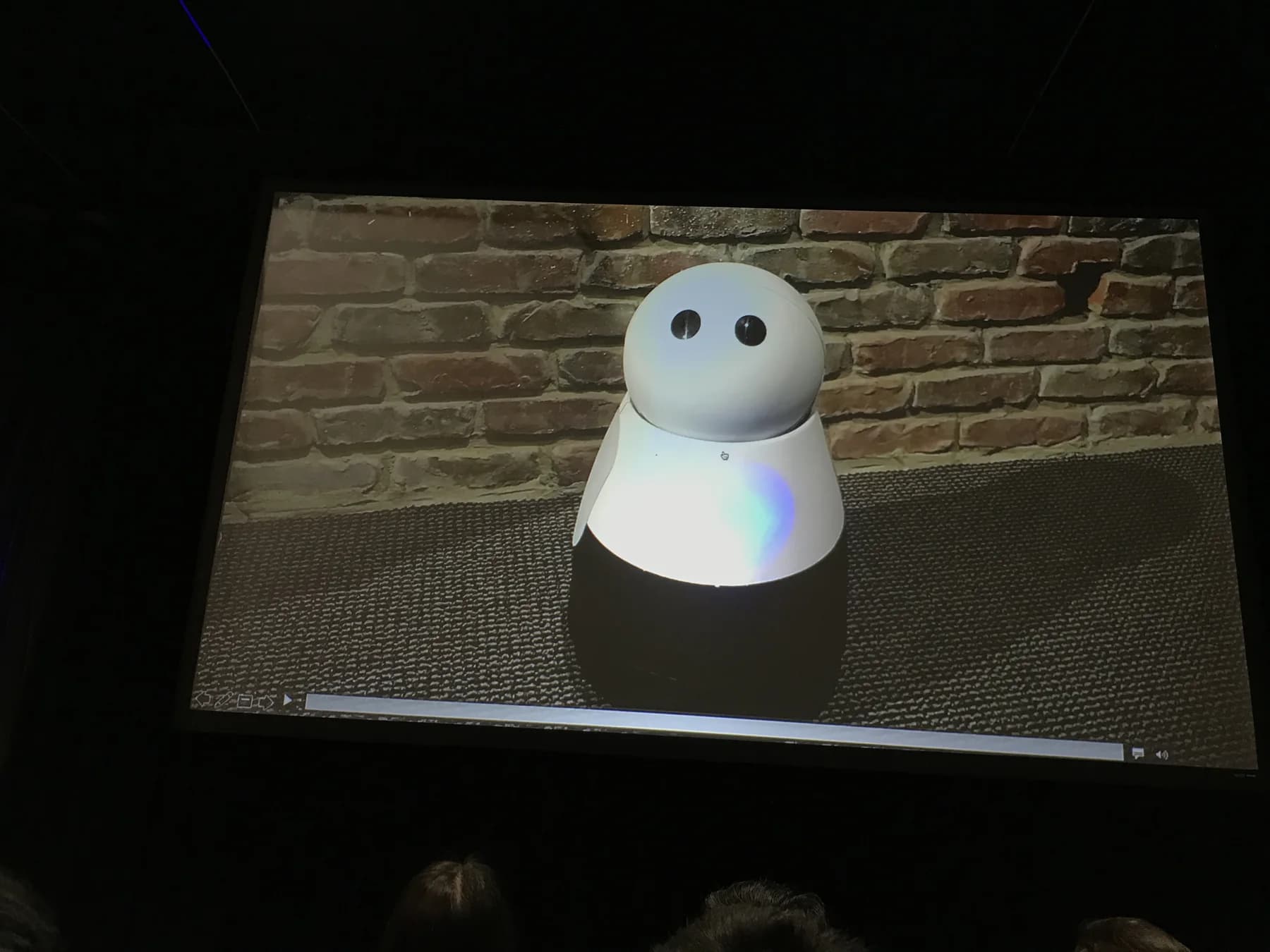 A projected demo image of a small white home robot shown at AI Frontiers 2017.