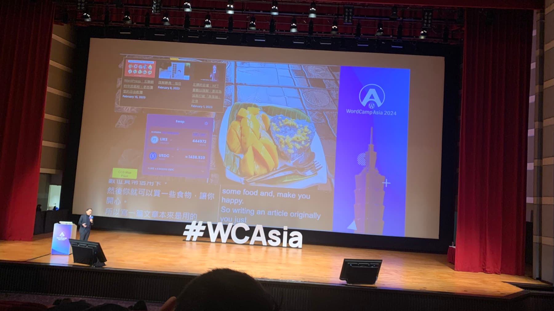A WordCamp Asia 2024 plenary stage in Taipei with a large projected slide, bilingual captions, and the #WCAsia sign in front.